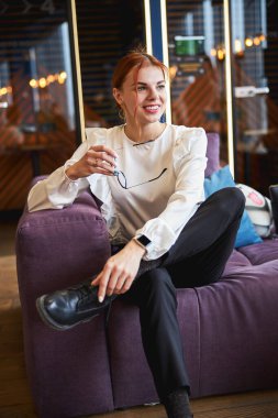 Ofisteki kanepede oturan çekici genç bayan.