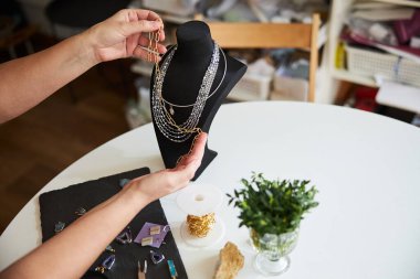 Yetenekli kadın yeni kolyesi için malzeme seçiyor.