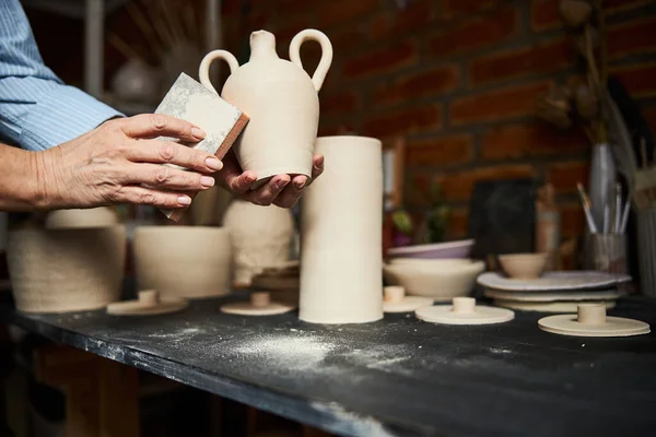 Femme potier mains polissage pot d'argile dans l'atelier de poterie — Photo