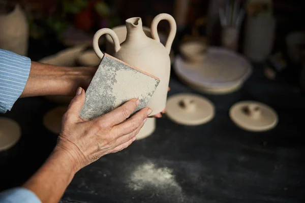 Femme potier mains polissage pot d'argile en atelier de poterie — Photo