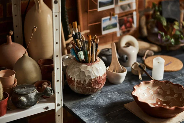Стіл з керамікою і пензлем в майстерні — стокове фото
