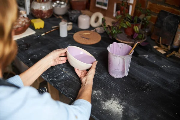 Artista de cerámica femenina pintando tazón de arcilla en taller — Foto de Stock