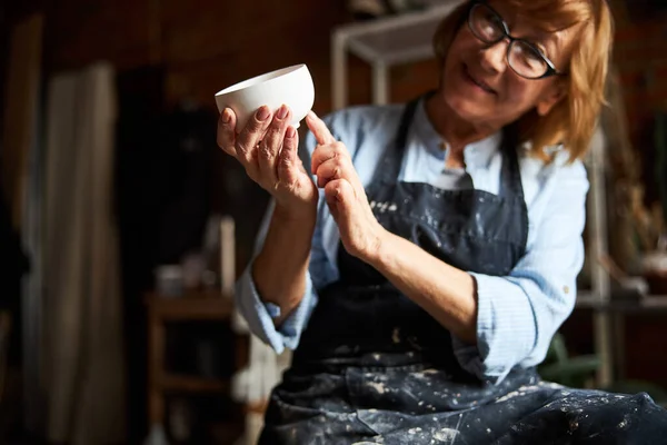 Жіноча кераміка демонструє глиняну чашу в керамічній майстерні — стокове фото