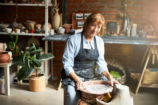 Charming old woman working in pottery workshop — Stock Photo, Image