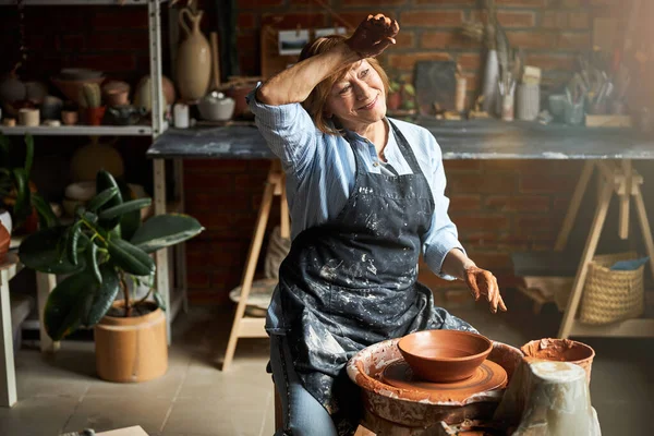 Cheerful senior woman making pottery in workshop — Stock Photo, Image