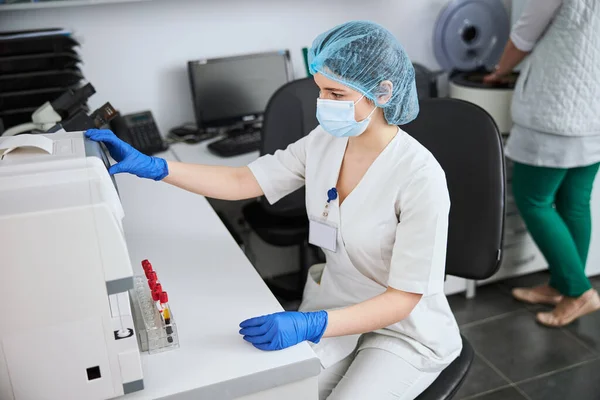 Scienziato di laboratorio concentrato utilizzando un analizzatore di biochimica — Foto Stock