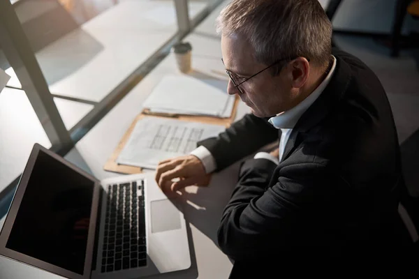 Seriös intelligent man med modern bärbar dator på kontoret — Stockfoto