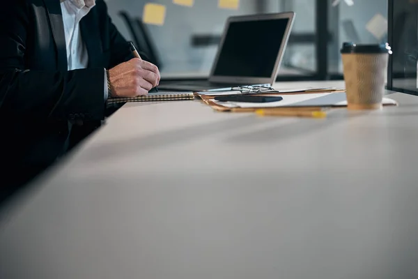 Manlig entreprenör skriver i anteckningsbok på jobbet — Stockfoto