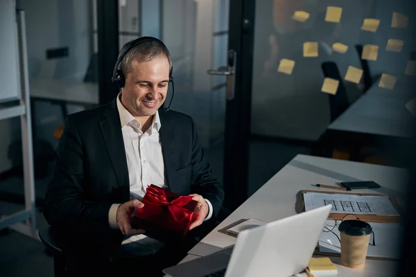 Fröhlicher Geschäftsmann mit Geschenkbox im Amt — Stockfoto