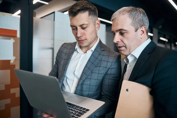 Två affärsmän använder modern bärbar dator i kontorskorridoren — Stockfoto