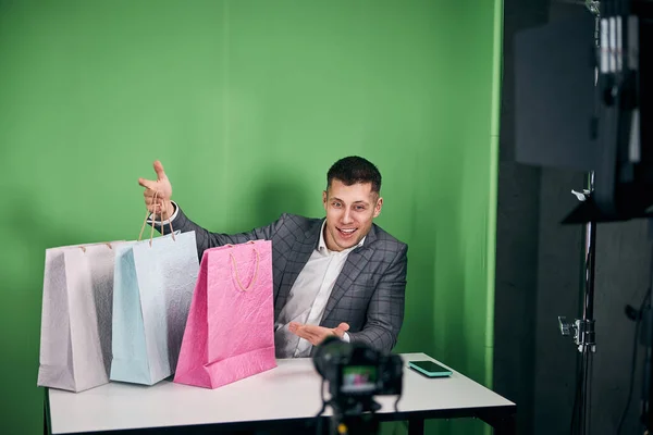 Fröhlicher junger Mann nimmt Video für Shopping-Blog auf — Stockfoto