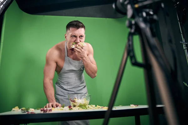 Atlético homem gravação de vídeo para blog e comer salada — Fotografia de Stock