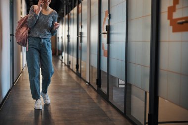 Sıradan giysiler içinde memnun bir çalışan akıllı telefonda sohbet ediyor.