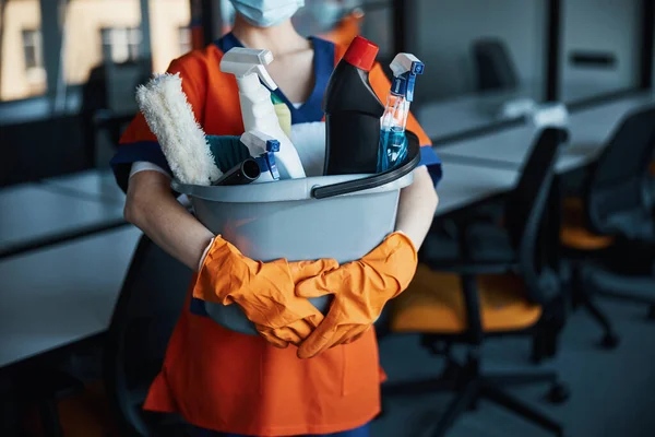 Limpiador en una mascarilla que muestra sus productos de limpieza —  Fotos de Stock