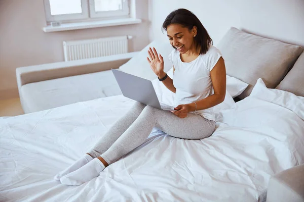 Χαρούμενη νεαρή γυναίκα που χρησιμοποιεί το laptop για online επικοινωνία — Φωτογραφία Αρχείου