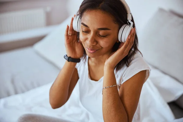 Attraktive junge Frau hört zu Hause Musik — Stockfoto