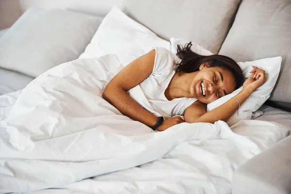 Vrolijke jonge vrouw rustend in bed thuis — Stockfoto