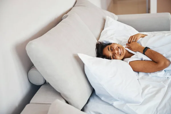 Vrolijke jonge vrouw liggend in bed thuis — Stockfoto