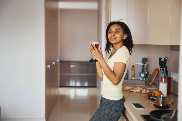Приваблива молода жінка п'є чай вдома — стокове фото