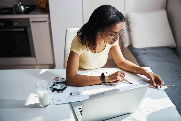 Vacker ung kvinna som arbetar med projekt hemma — Stockfoto