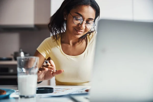 Charmig ung kvinna som arbetar med projekt hemma — Stockfoto