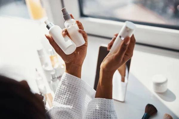 Female hands holding bottles of cosmetic cream and lotion — Stock Photo, Image