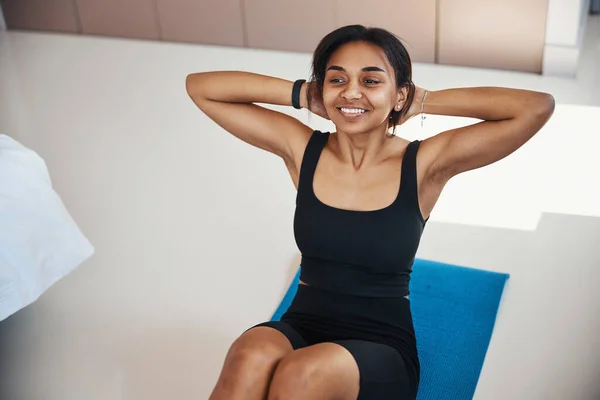 Jovem alegre fazendo exercício para abdominais em casa — Fotografia de Stock