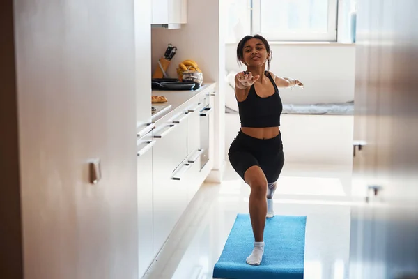 Attraente giovane donna che pratica yoga a casa — Foto Stock