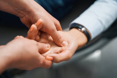 Sertifikalı refleksolog akupunktur seansı sırasında kadına masaj yapıyor.