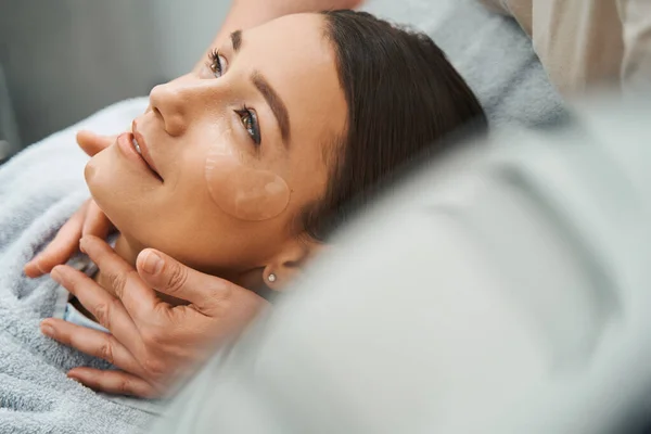 Усміхнений мрійливий курортний клієнт отримує масаж шиї — стокове фото