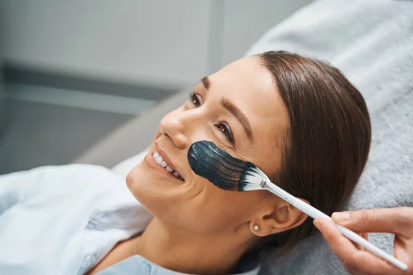 Kvinnlig patient ler under en kosmetisk procedur — Stockfoto