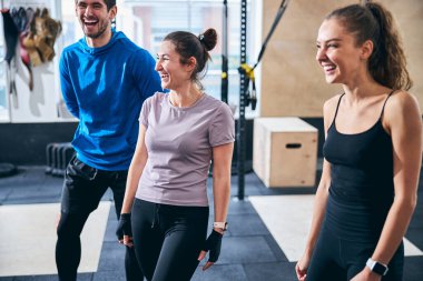 Yakışıklı erkek ve bayan sporcular antrenman sırasında gülüyorlar.