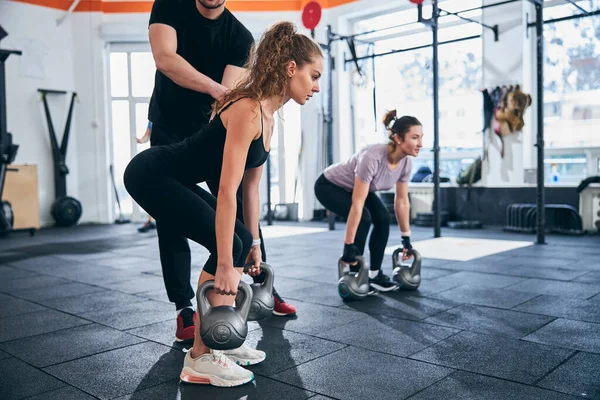 Dos mujeres deportistas haciendo un ejercicio de entrenamiento de fuerza — Foto de Stock