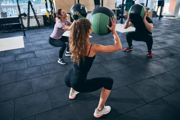 Tre personer gör knäböj med stabilitetsbollar — Stockfoto