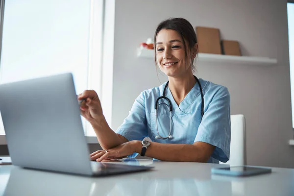 현대 노트북을 사용하는 여성 의사를 소개하는 모습 — 스톡 사진