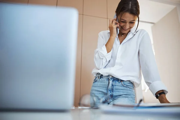 Femme gaie parlant sur téléphone portable au travail — Photo