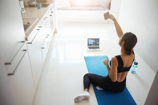 Mujer deportiva tomando fotos con smartphone en casa — Foto de Stock