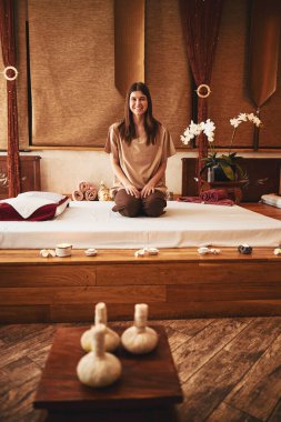 Diz çöküp masaj salonundaki neşeli kadın.