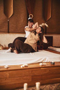 Dost canlısı Taylandlı masöz kadını kolundan çekip alıyor.