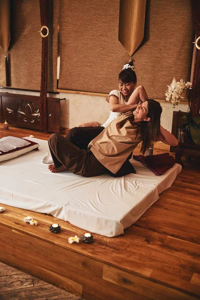 Praticante de massagem de ioga tailandesa trabalhando em músculos do braço do cliente — Fotografia de Stock