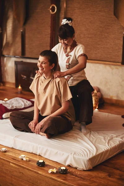 Signora in posizione di loto che riceve massaggio tailandese sul collo — Foto Stock