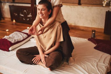 Masaj terapisti iki kolunu kadının omuzlarına koydu.