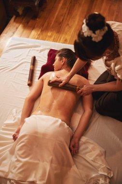 Tecrübeli masaj terapisti tekerlekli sandalyeyle derin doku masajı yapıyor.