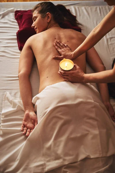 Mano del massaggiatore diffusione cera sulla colonna vertebrale femminile — Foto Stock