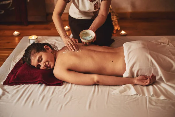 Creme de espalhamento adulto de massagem em costas de fêmea — Fotografia de Stock