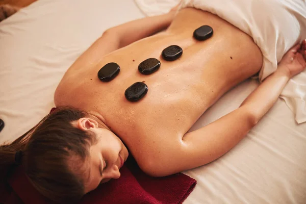 Massagem de pedras na coluna vertebral e parte superior das costas do cliente spa — Fotografia de Stock
