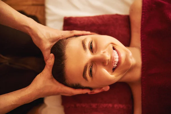 Jonge vrouw glimlachen van aangename hoofd massage — Stockfoto