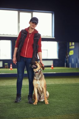 Huzurlu bir bayan eğitmen ve eğitim sırasında bir köpek.