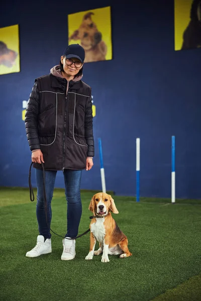 Lindo cachorro tricolor y un controlador sonriente mirando hacia el futuro —  Fotos de Stock