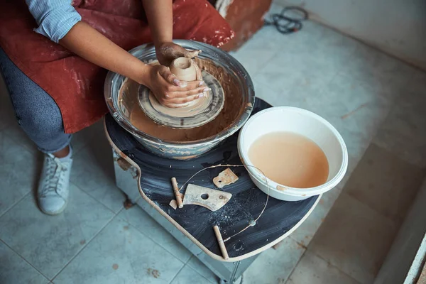 Jeune femme céramiste jetant pot d'argile sur roue de poterie — Photo